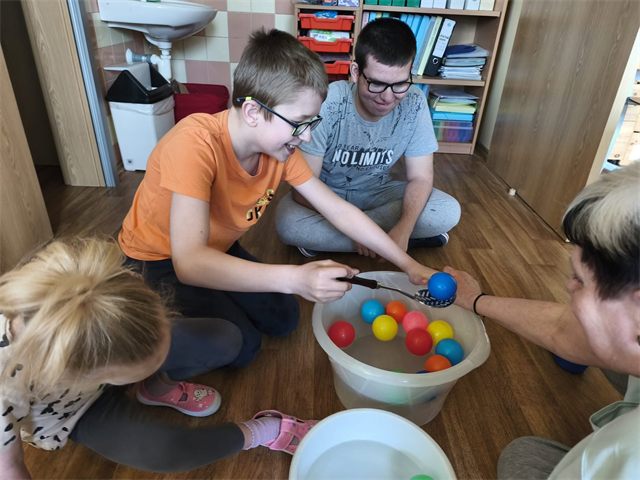 Žáci loví barevné míčky z vody při společné činnosti