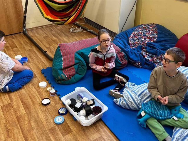 Žáci v relaxační místnosti s polohovacími vaky a houpací sítí